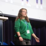Enya talking to an audience - looking usually dismayed