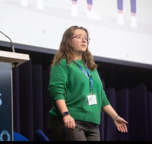 Enya talking to an audience - looking usually dismayed